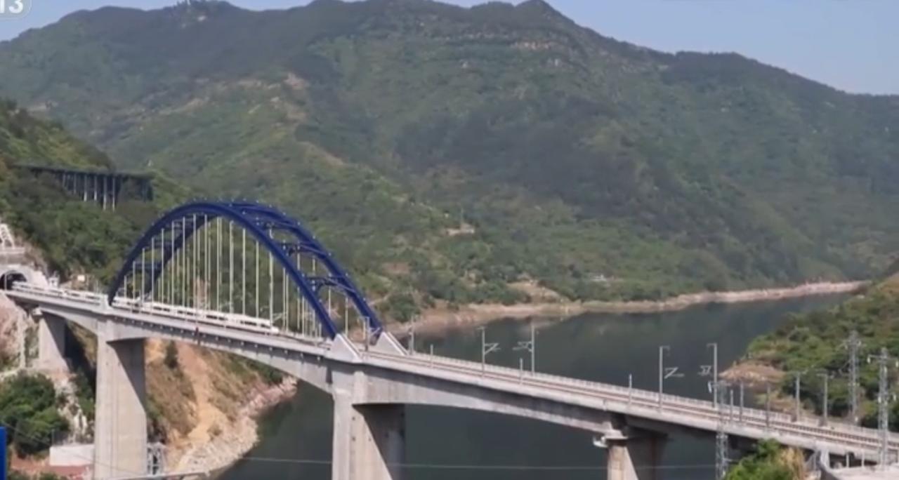 第一张图中，蓝色钢拱的大桥横跨碧水，混凝土桥身与青山绿水相映，现代工程的雄健与自