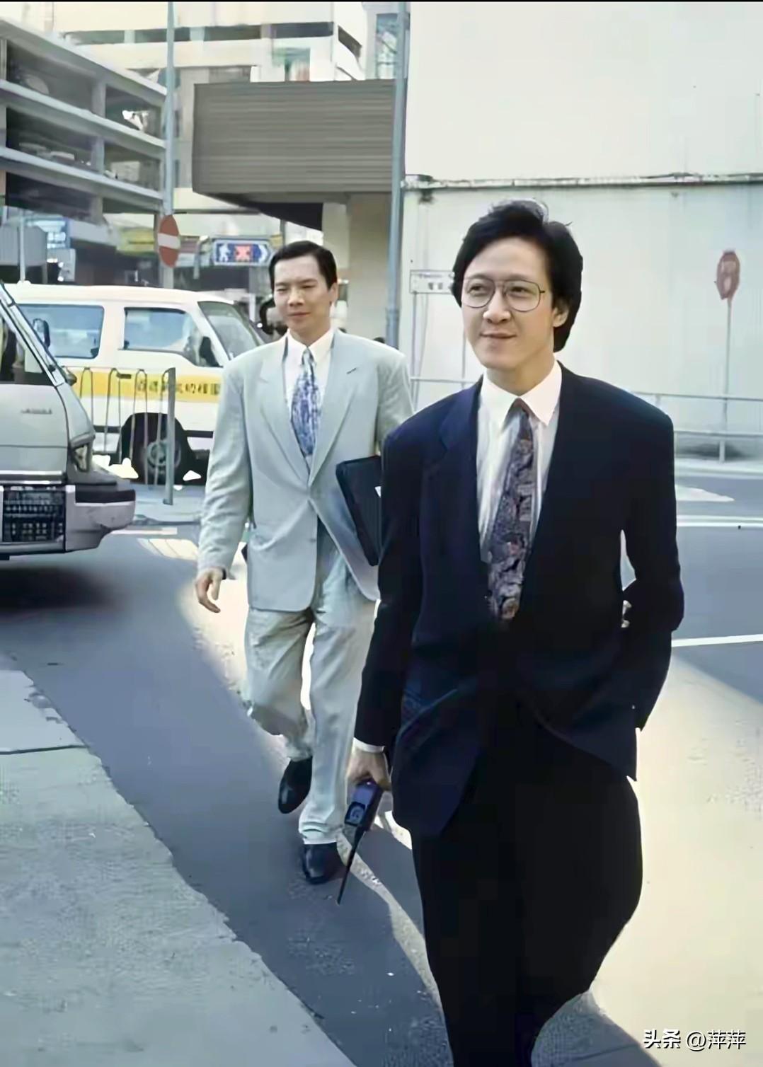 这是90年代香港街头的向氏兄弟：向华胜（前）与向华强（后）。两人西装革履，向华胜