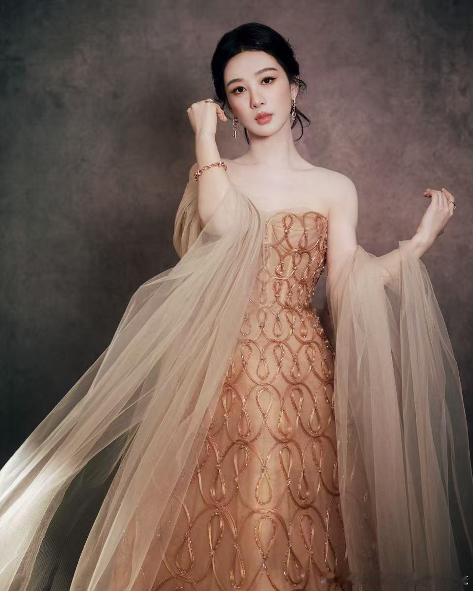 落日鎏金落于肩头，杨紫身着Phan Huy春夏高定抹胸长裙亮相。裙身手工编织环纹