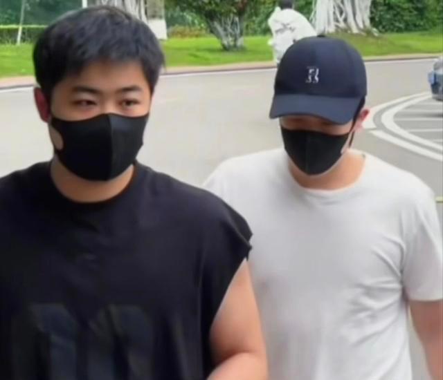 国乒集体放半天假，和队友曹巍一起打车外出。短袖+短裤+灰色洞洞鞋（鞋带还散着）。