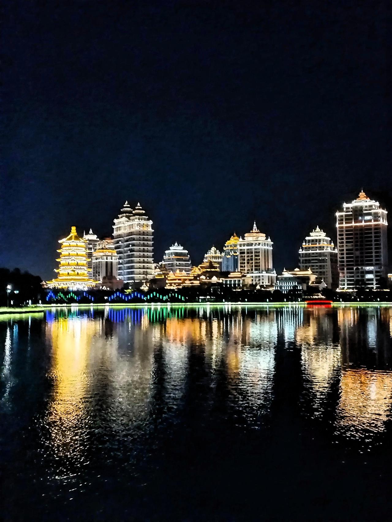 沿着湖边小径漫步，湖水在灯光的映照下闪烁着粼粼波光，像是洒下了无数颗细碎的钻石。