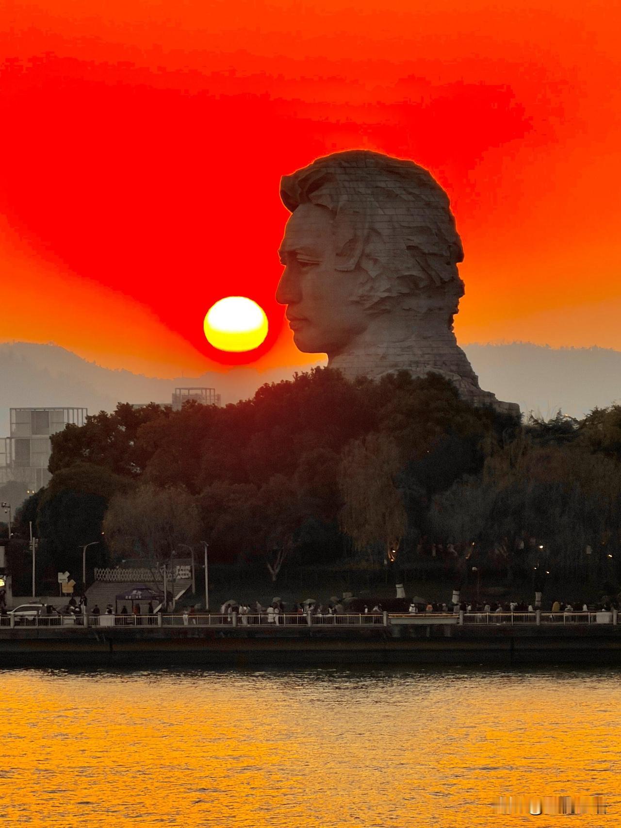 大年初四的橘子洲，日落美到失语。
余晖给青年雕塑镀上金边，
湘江水泛着金光，风里