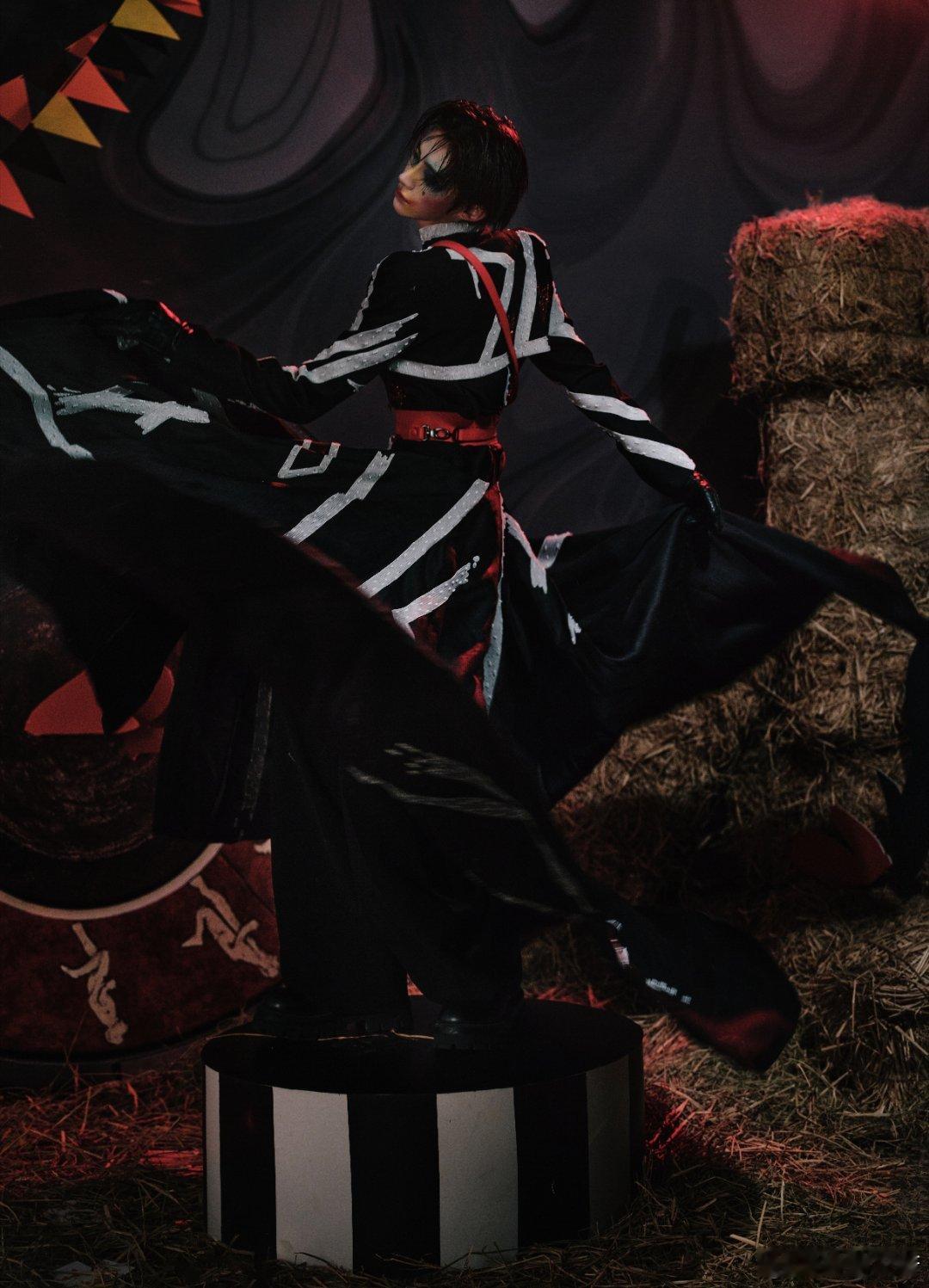 宽檐帽压着星子般的眼，黑白条纹在身畔织成流动的琴弦。红绸如焰缠绕骨感腰线，手杖轻