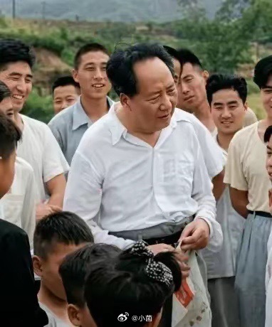 毛主席身着简洁的白衬衫，笑容爽朗，目光亲切，仿佛正和身边的人们畅谈。周围的群众脸