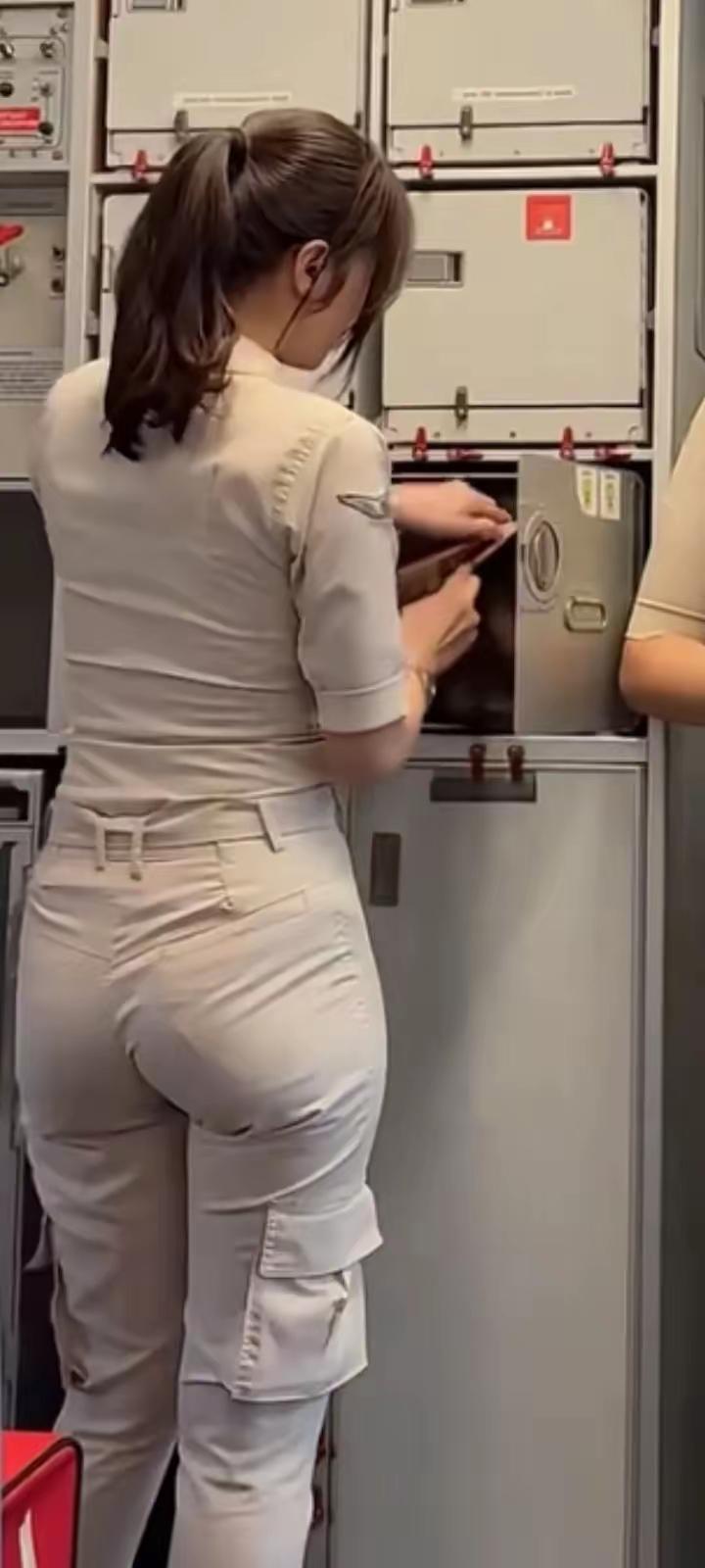 空姐日常工作照，专注检查设备，确保安全！🛫️💼