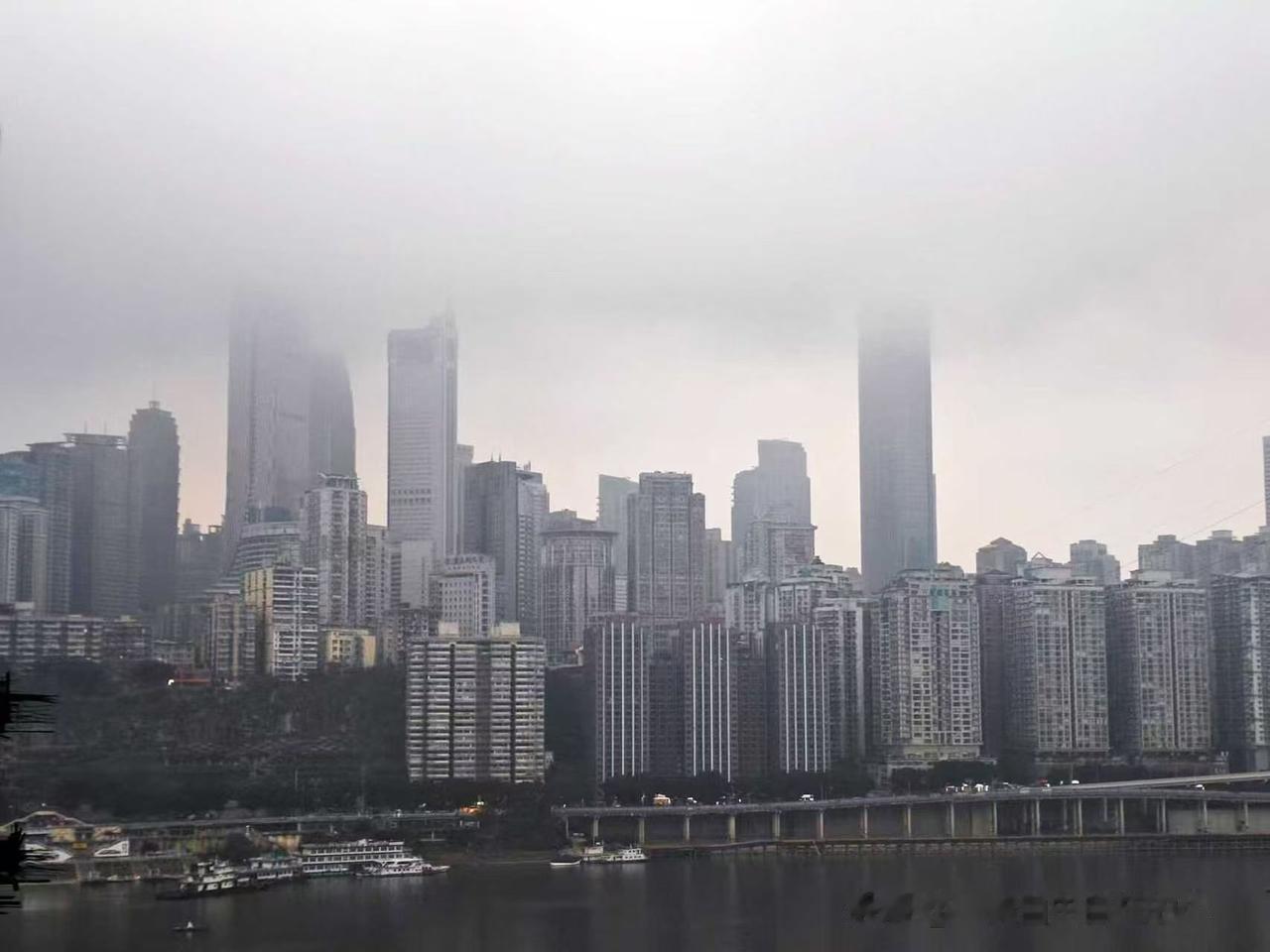 薄雾笼罩着整座城市，高楼大半隐在白茫茫雾气里，只露出半截楼宇，平添几分朦胧氛围感