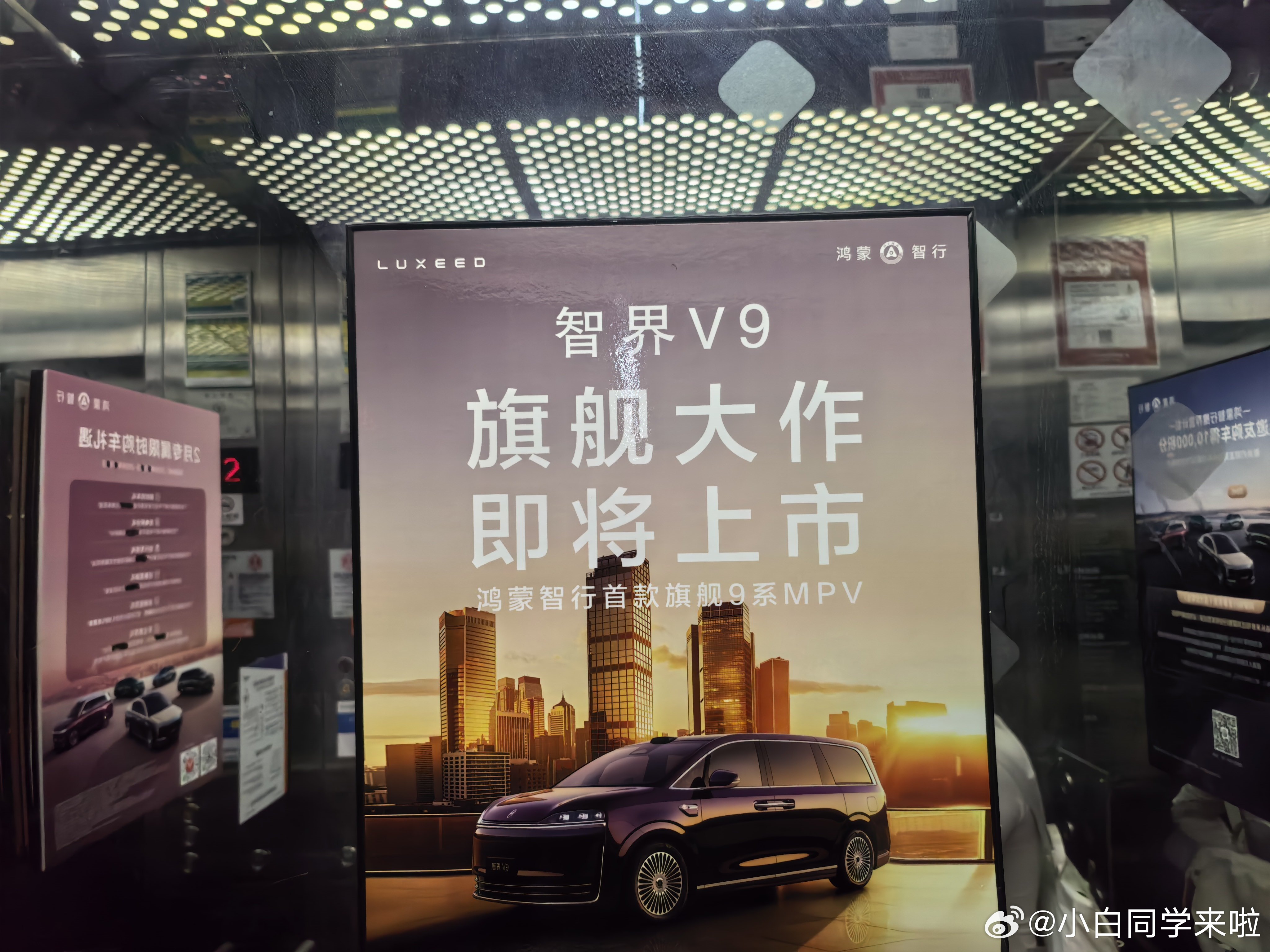 “旗舰大作即将上市”，深圳湾鸿蒙智行电梯里已经挂上了智界 V9 的广告牌。新能源