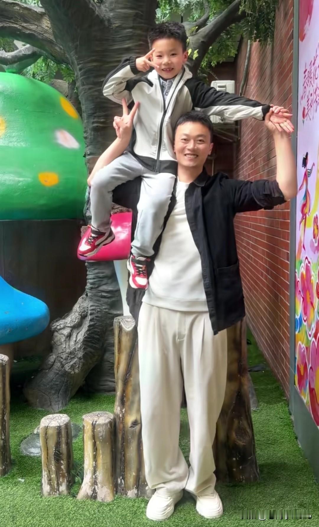 秋天爸爸把秋天扛在肩膀上，两只手紧紧攥着娃的手，笑得那叫一个敞亮！配文那句“有爸