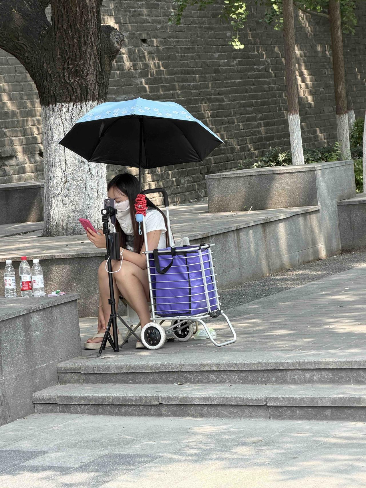 昨天上午11点左右，我在西安西门里的北马道巷南口，看到两位年轻女士，冒着酷暑，在