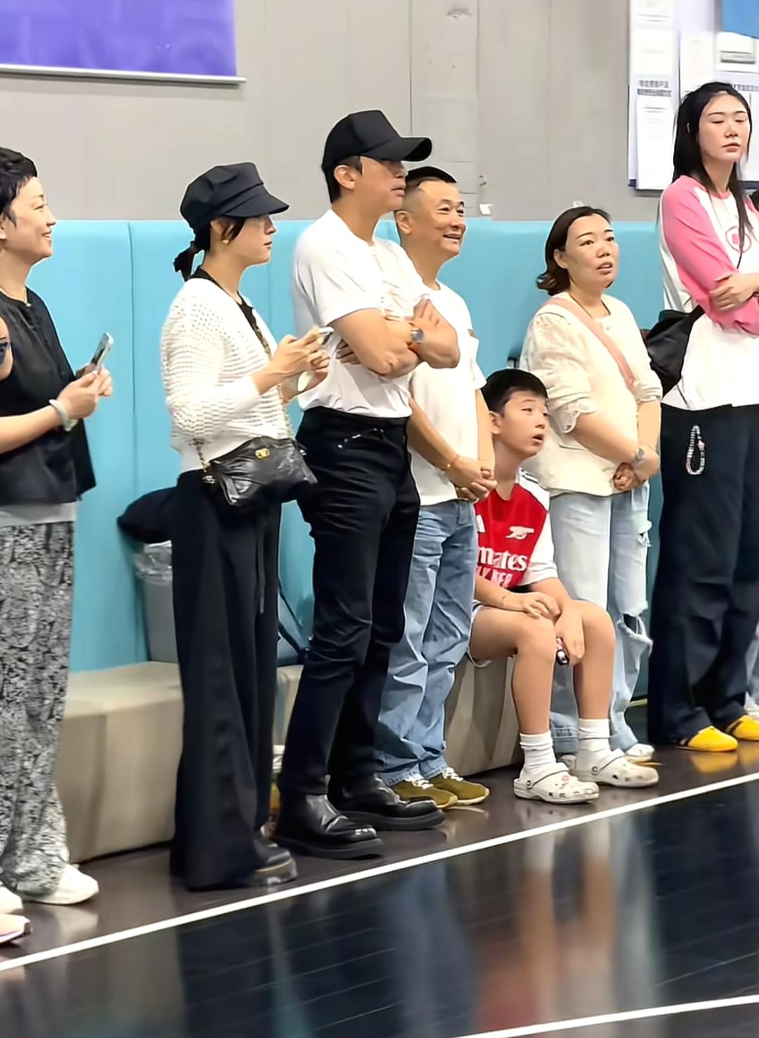 邓超和孙俪在上海体育馆看儿子打篮球比赛，夫妻俩穿着日常服饰，亲自站在场边支持儿子