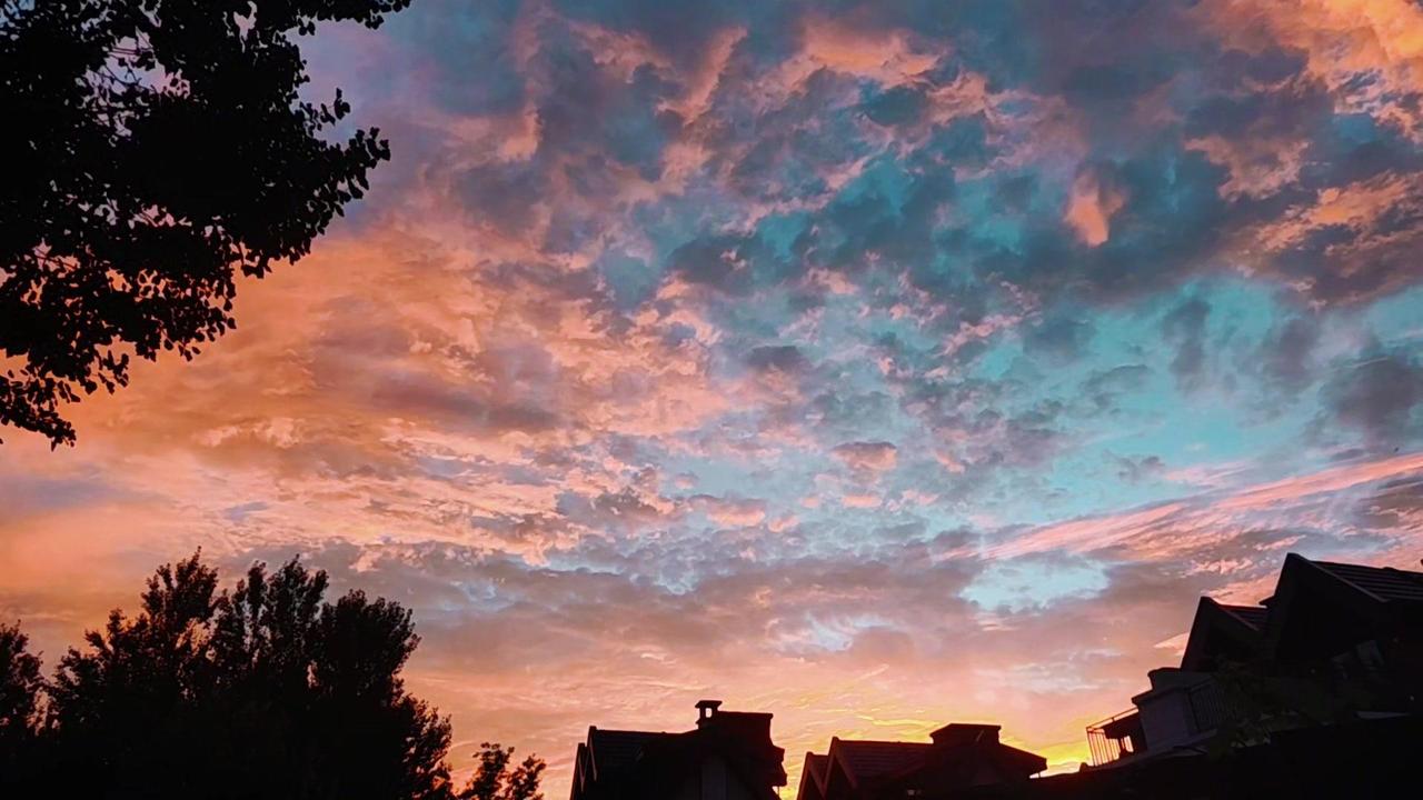 🌅北京密云的晚霞太绝了！像被打翻的调色盘，天空被染成了渐变的粉紫和金黄，云朵被