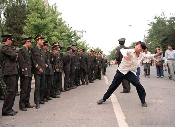 1999年5月9日北京抗议活动的第二天，一名抗议者向美国大使馆投掷石块。 