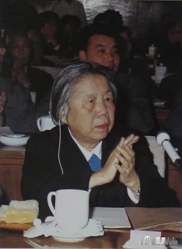 七十年代后期，在北京人民大会堂会议现场，邓颖超参加重要会议。她端坐席位，认真聆听