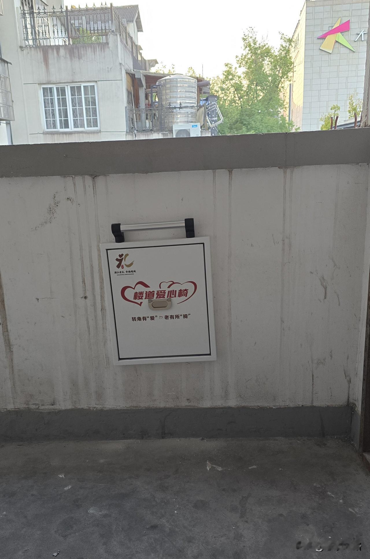 今天下楼时发现三楼的休息平台处安装了一个折叠楼道爱心椅，应该是街道社区安排的民心