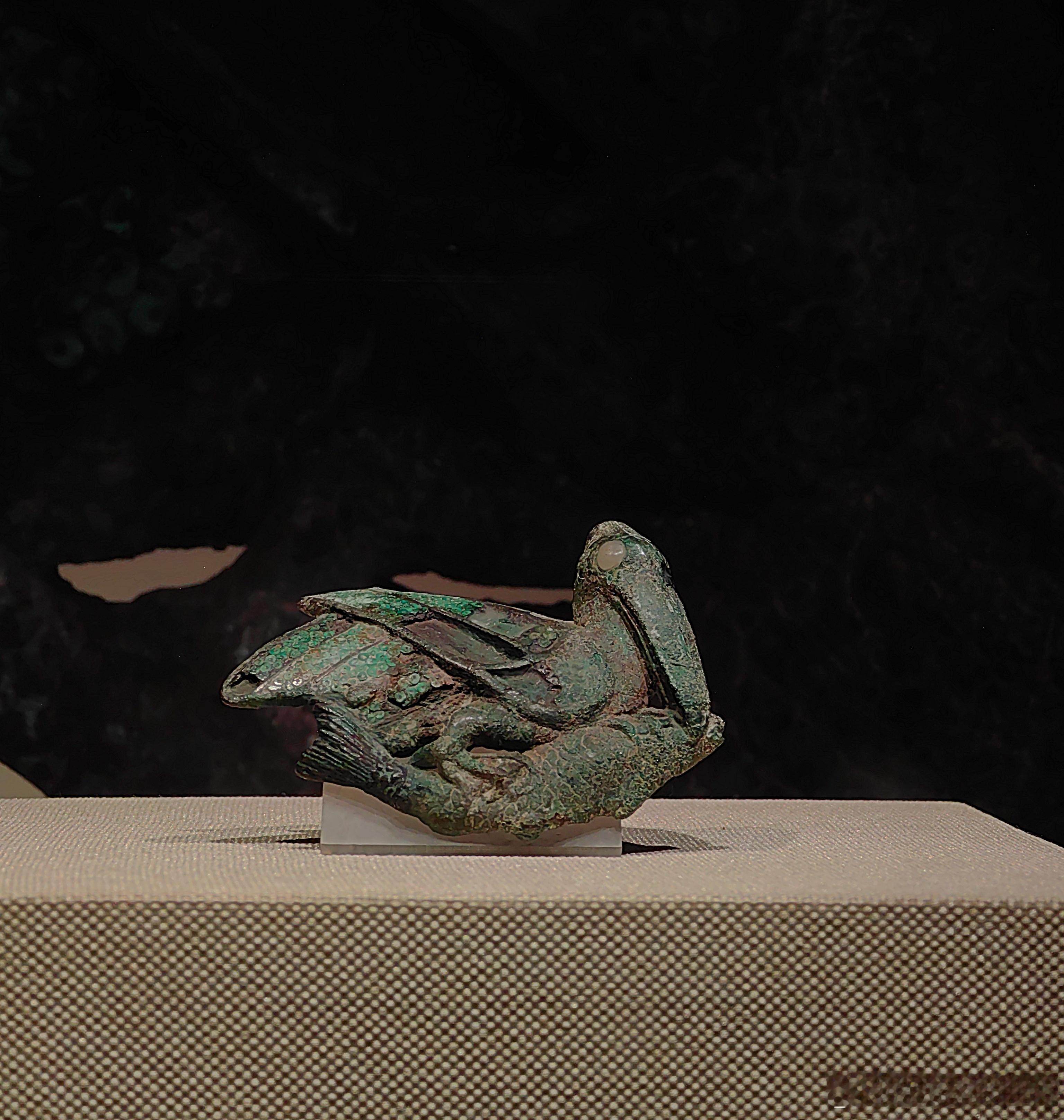 鹈鹕衔鱼铜扣饰西汉（公元前202-公元8年）云南省博物馆藏云南晋宁石寨山出土。器