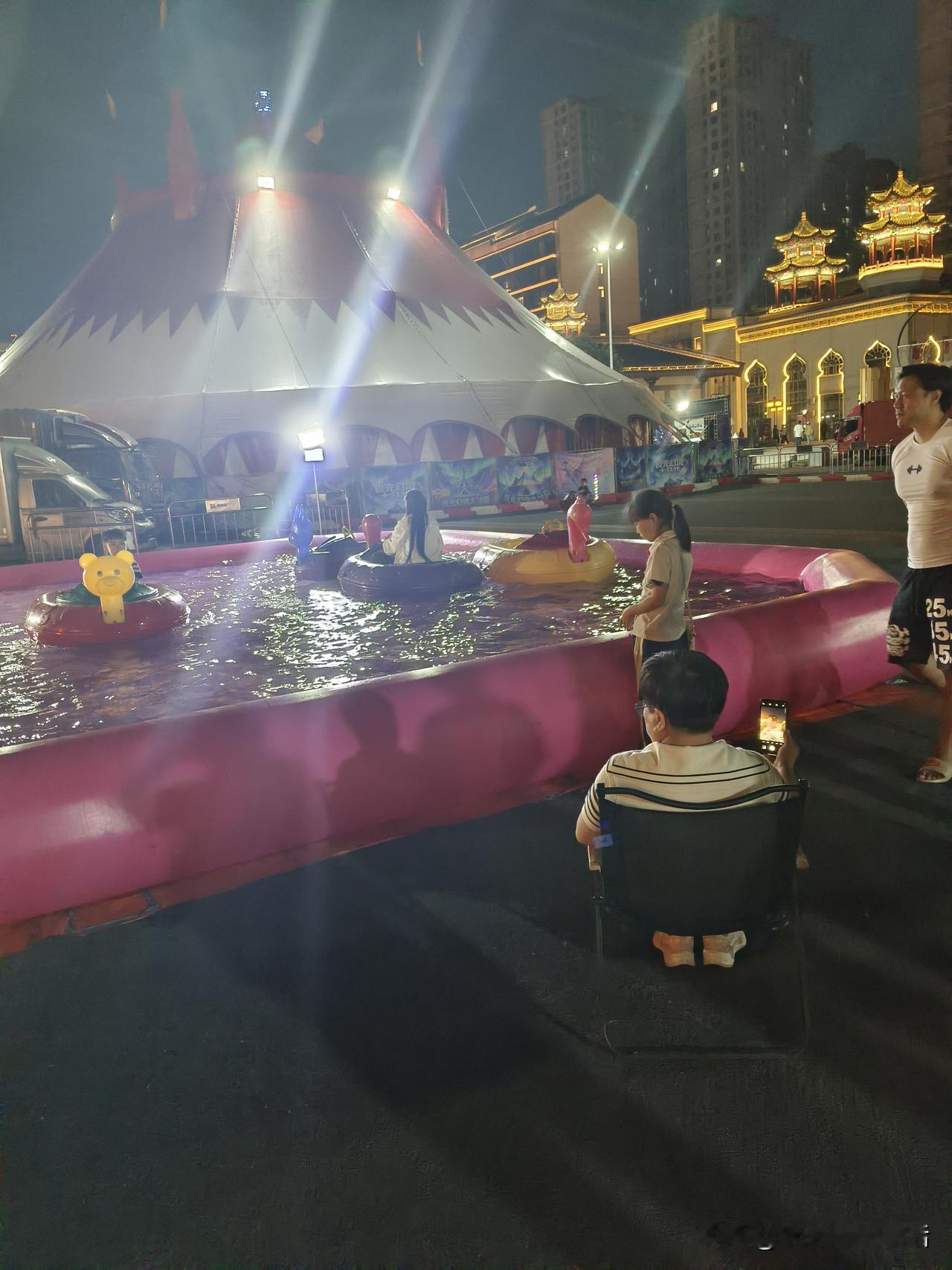 夜晚游乐场，小朋友玩碰碰船。水上儿童游乐场