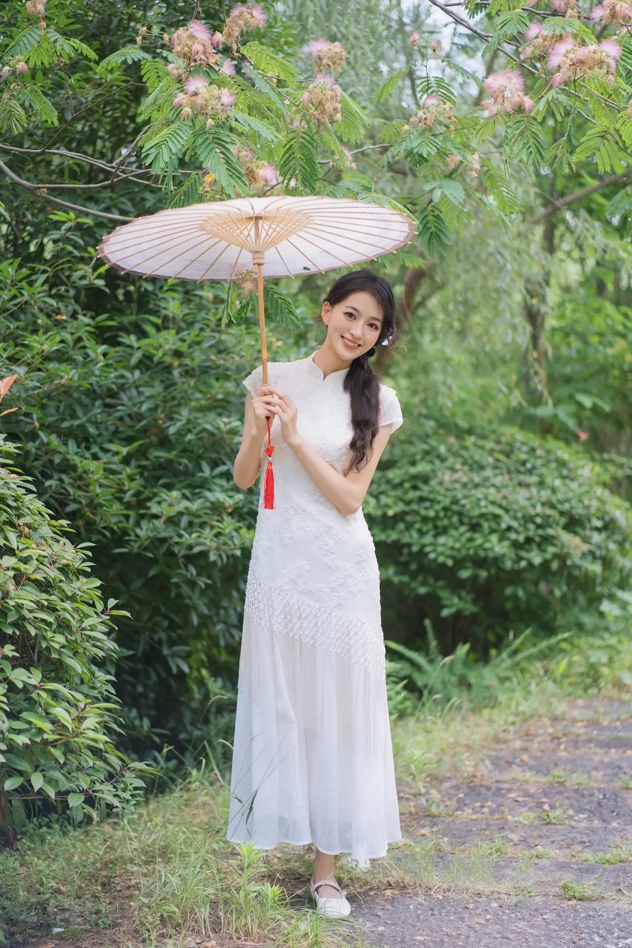 清新夏日，撑伞漫步在绿意盎然的林间小道，感受自然的宁静与美好。