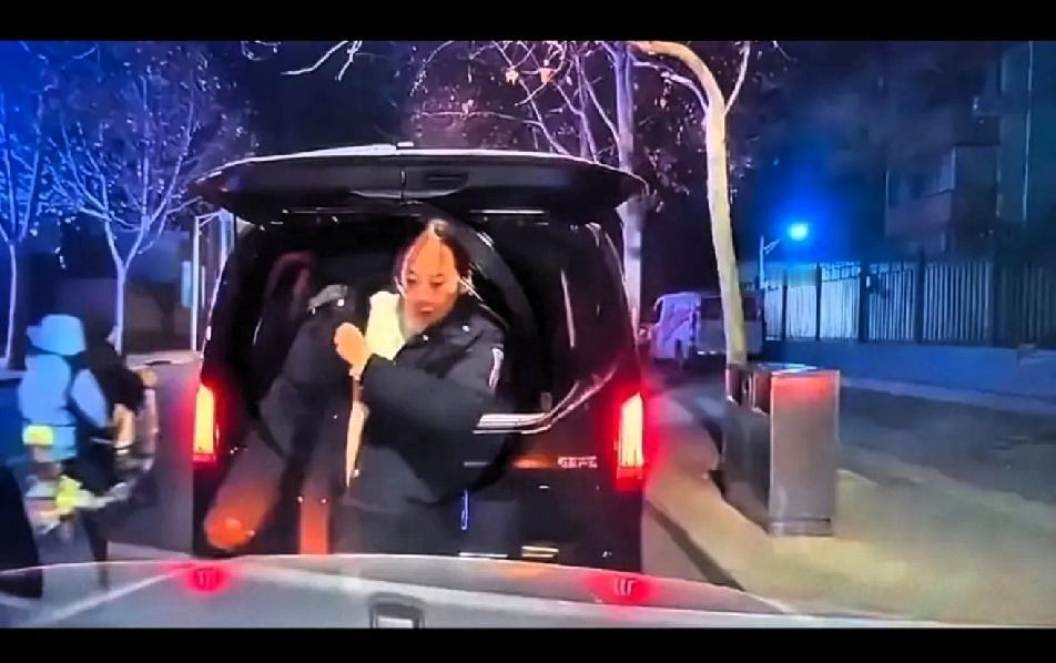 某街道，两个女车主因为冲突在路边等待交警的到来。北京奔驰女车主非常淡定从奔驰后备