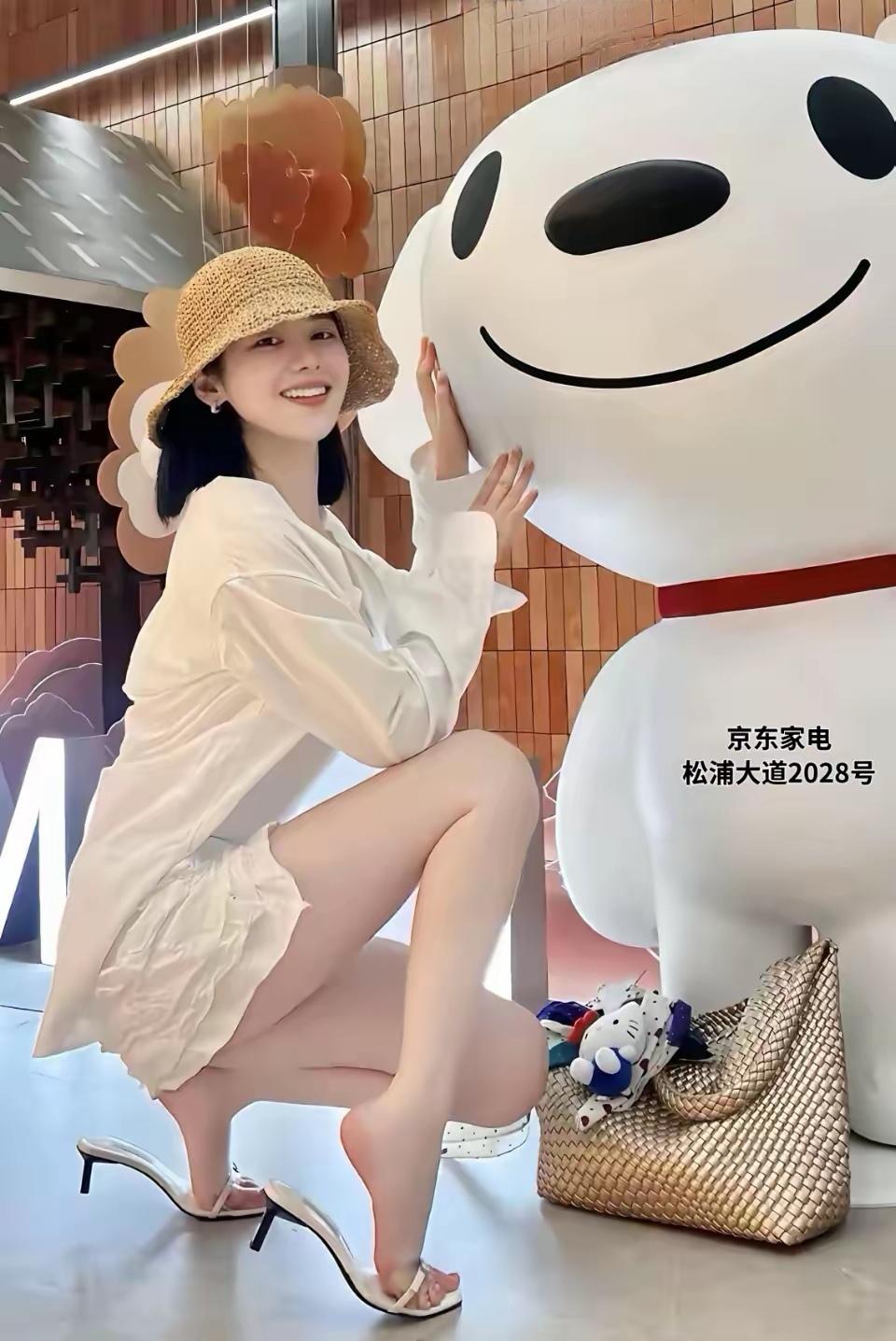 小姐姐在跟卡通人偶合照呢。