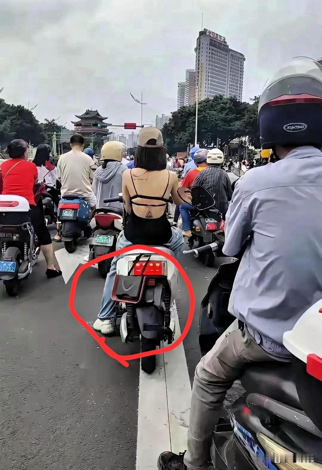 现在女人真胆大，包包挂在电动车后面，就不怕别人给你拿走。