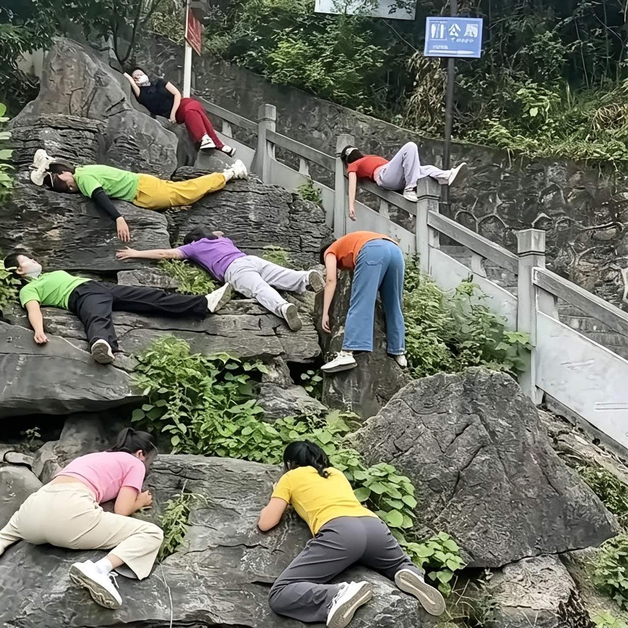 第一眼看到，差点被这画面给逗乐了！
 
一群人趴在、躺在公园的大石头上，姿势五花