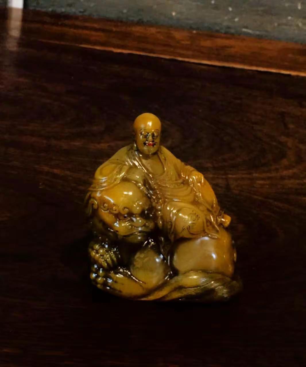 版本1 寿山田黄石伏狮罗汉摆件。田黄石质温润凝腻，蜜黄通透，自带古朴包浆。随形圆