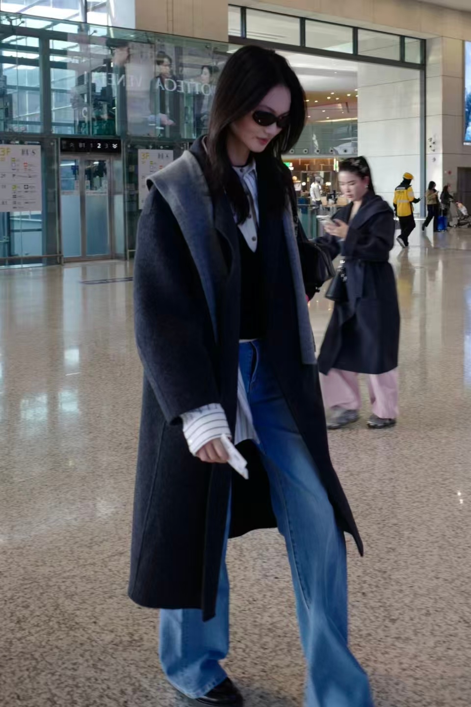 贺聪机场穿搭教科书贺聪机场造型，灰黑拼色双面呢大衣叠穿条纹衬衫，配阔腿牛仔与厚底