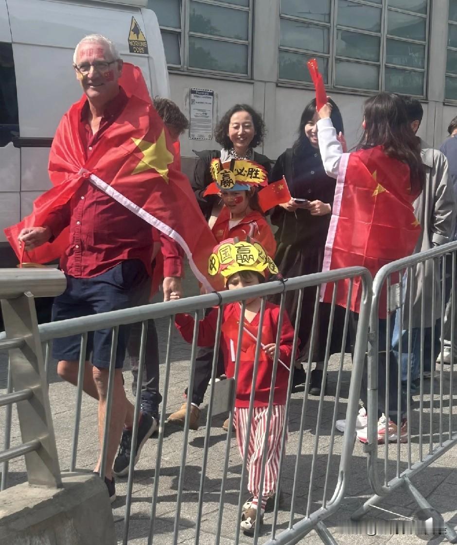 看到这图，
感受到一个中国女人的含金量。
在英国拉上一个外国女婿，
披上中国国旗