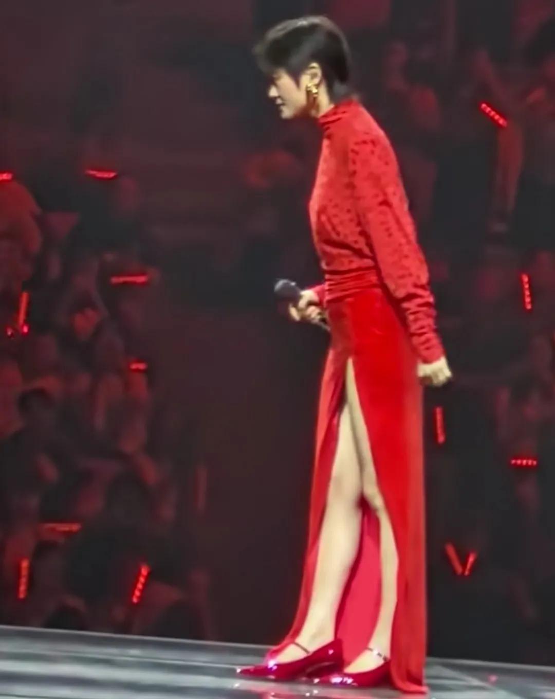 歌星李宇春穿红裙子向观众鞠躬。