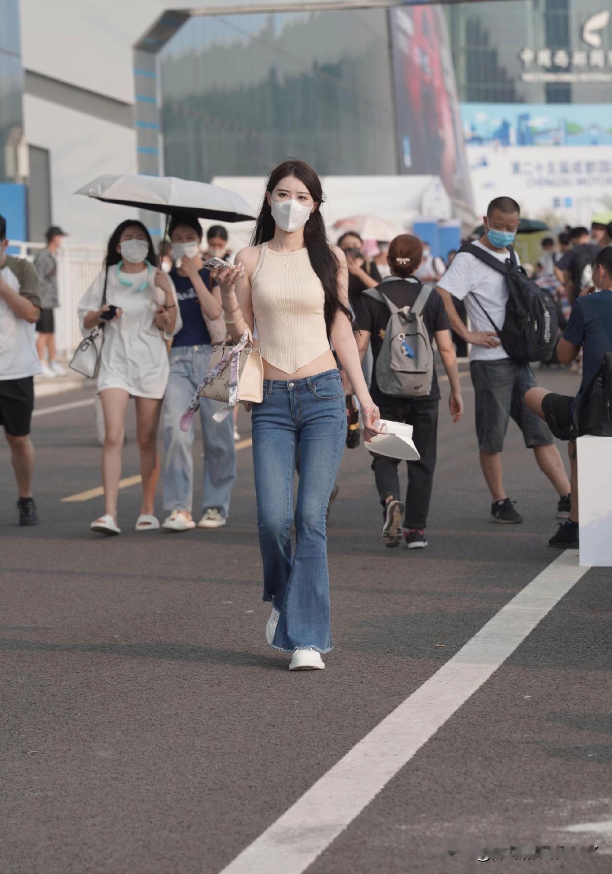 都市街头时尚穿搭总能带来惊喜。今年春夏，米白缎面方领吊带搭配多层荷叶边蛋糕裙成了