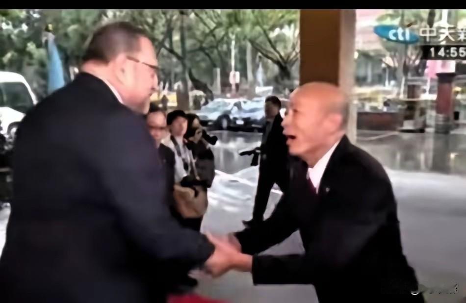 画面右侧的光头人物是韩国瑜，他双手紧紧握住对方的手掌，身体前倾，脸上挂着夸张的笑