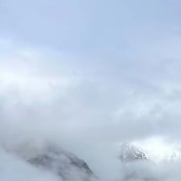 船行于辽阔的湖面之上，满目是沉静而苍茫的山河。湖水占据画面大半视野，幽深的蓝青色
