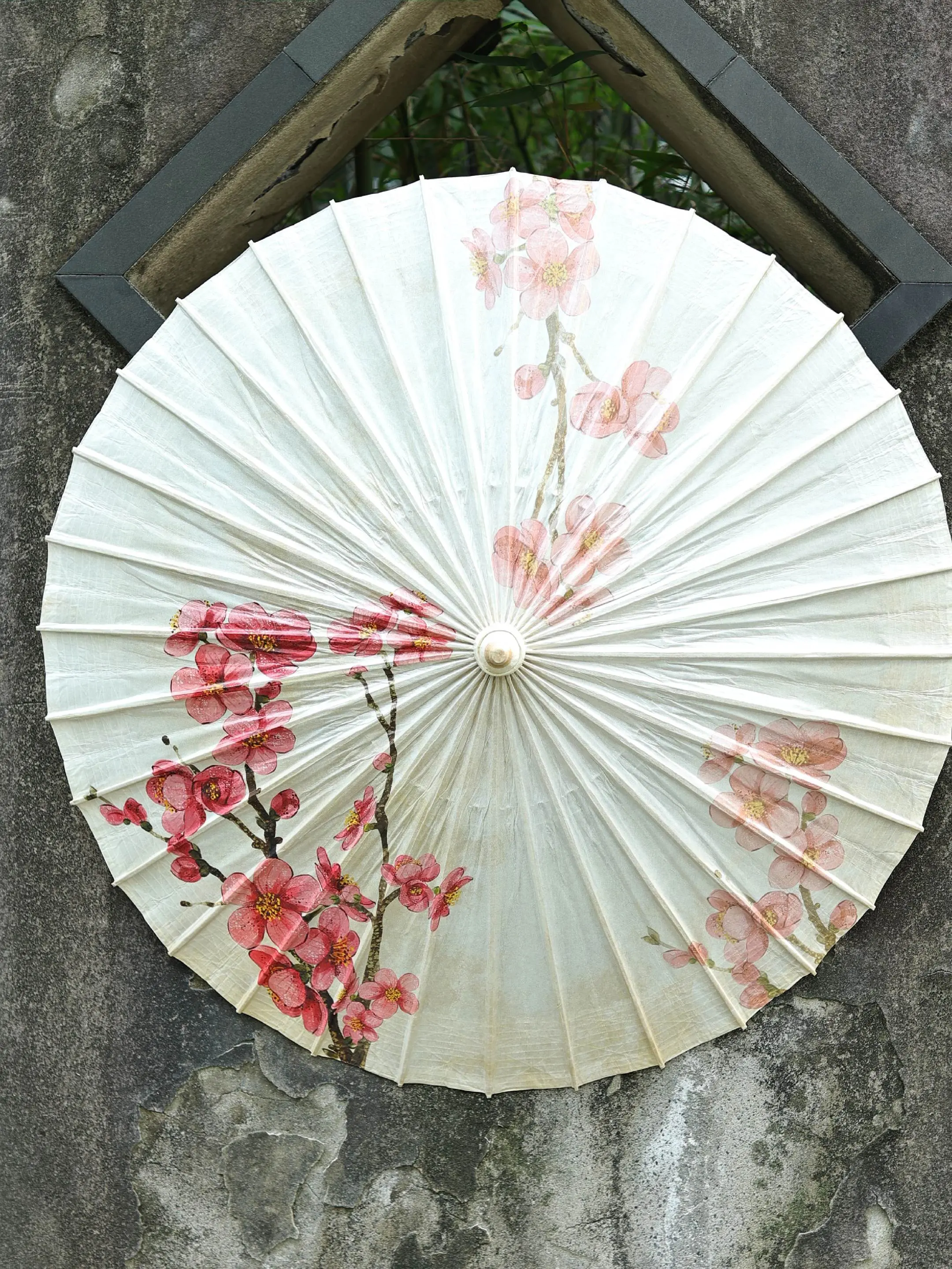 【繁花系列】海棠花·油纸伞。桐油浸透的伞面泛着温润的光，伞骨撑起的弧度...