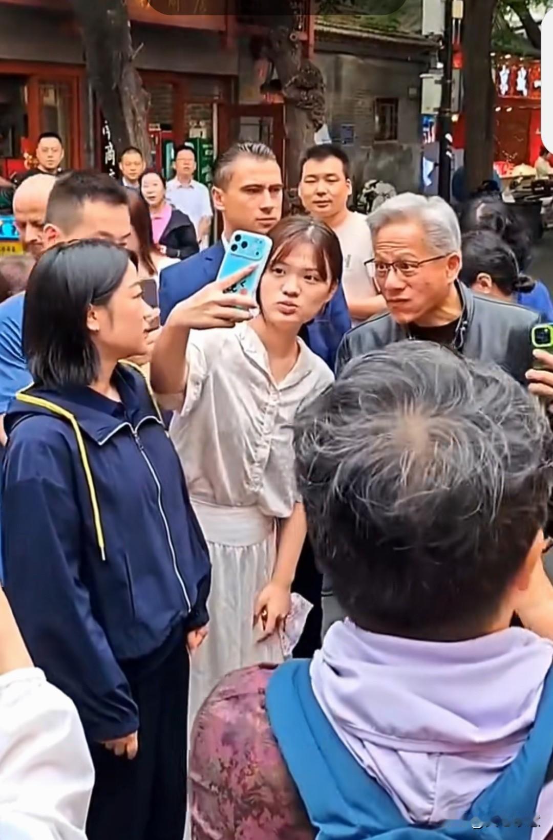 在热闹的北京胡同，一头银发，身穿标志性皮衣的黄仁勋，一下子就被大家认出来了。
