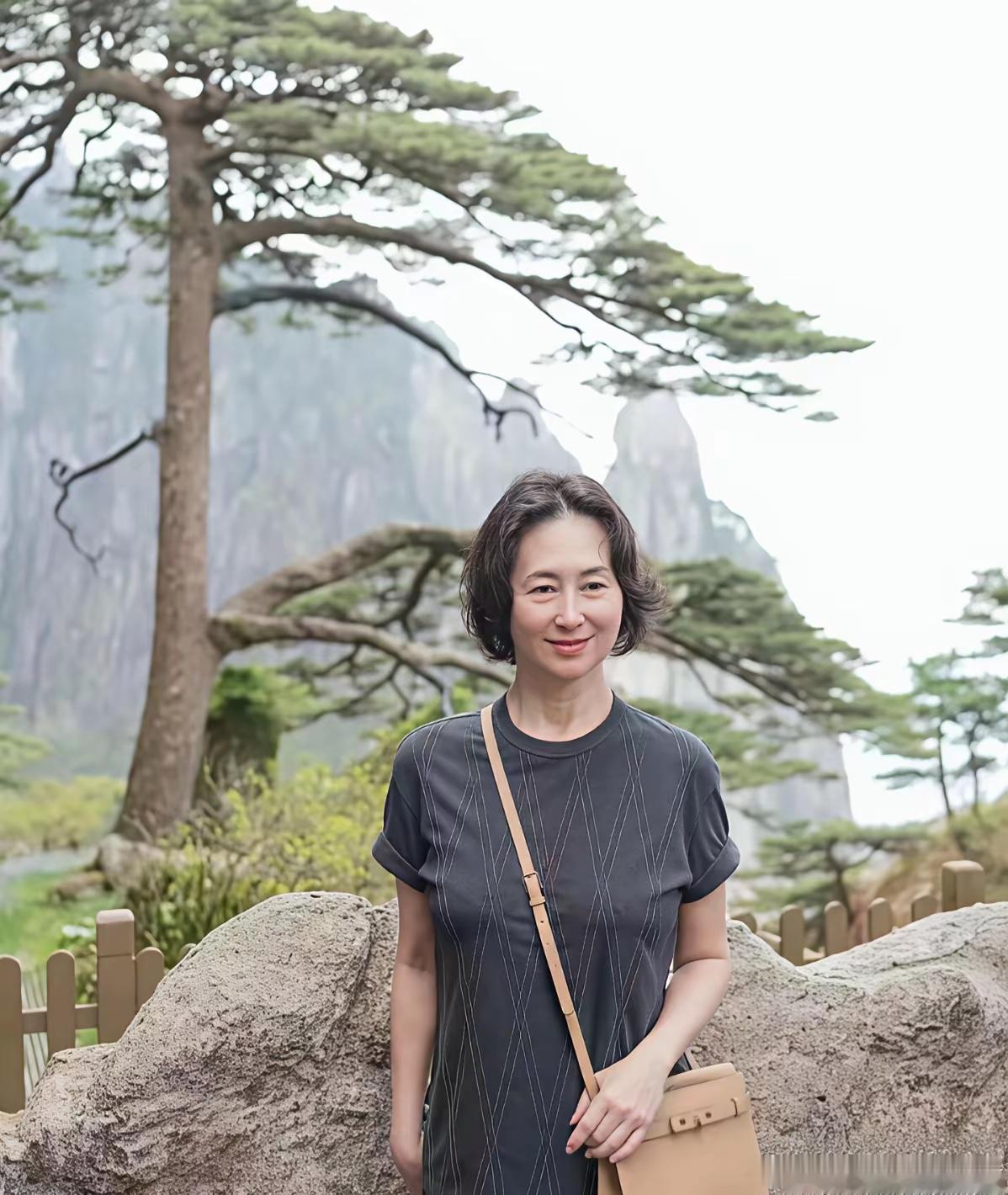 何超琼浏览黄山美景。
是什么让岁月不败美人？是那份从容淡定的微笑，是登山杖下的坚