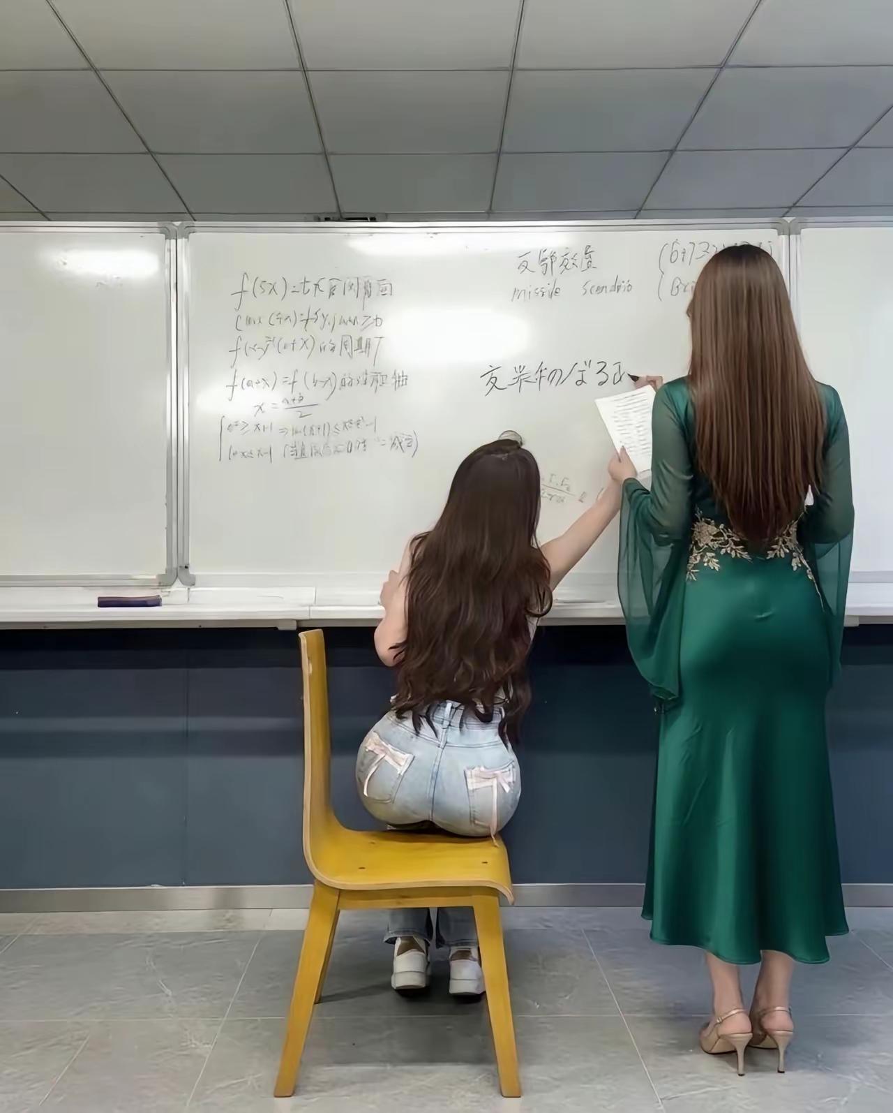 正常来说应该是老是坐着学生站着，因此坐着的是老师，站着的是学生。

正常来说应该