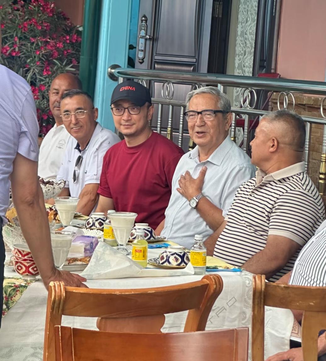 央视著名主持人小尼回到新疆老家，和老家的友人团聚，小尼戴着印有中国的英文字母的黑