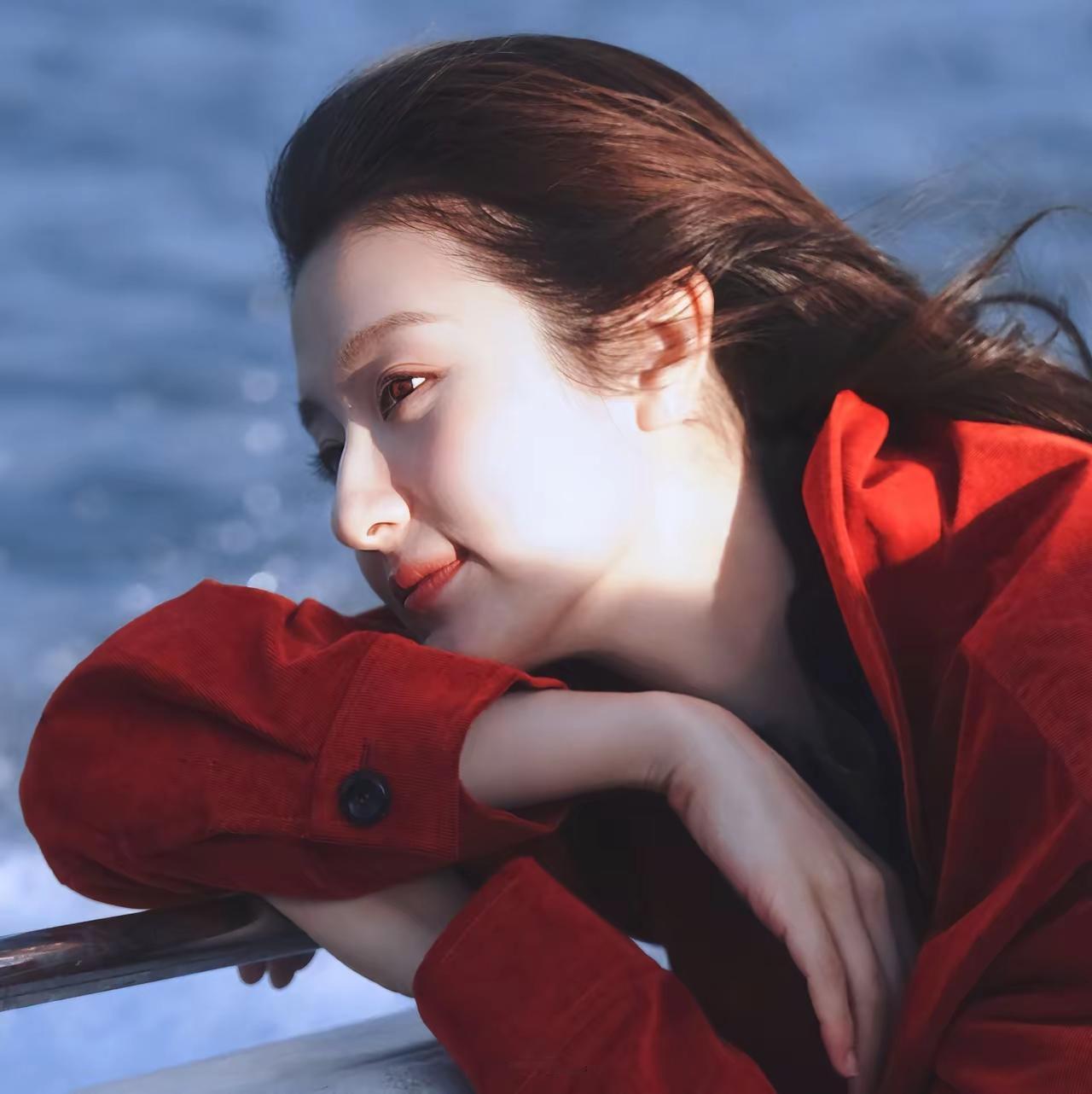 阳光洒下的温柔瞬间，红衣少女倚靠栏杆，静享美好时光。
李兰迪，中国内地女演员，童