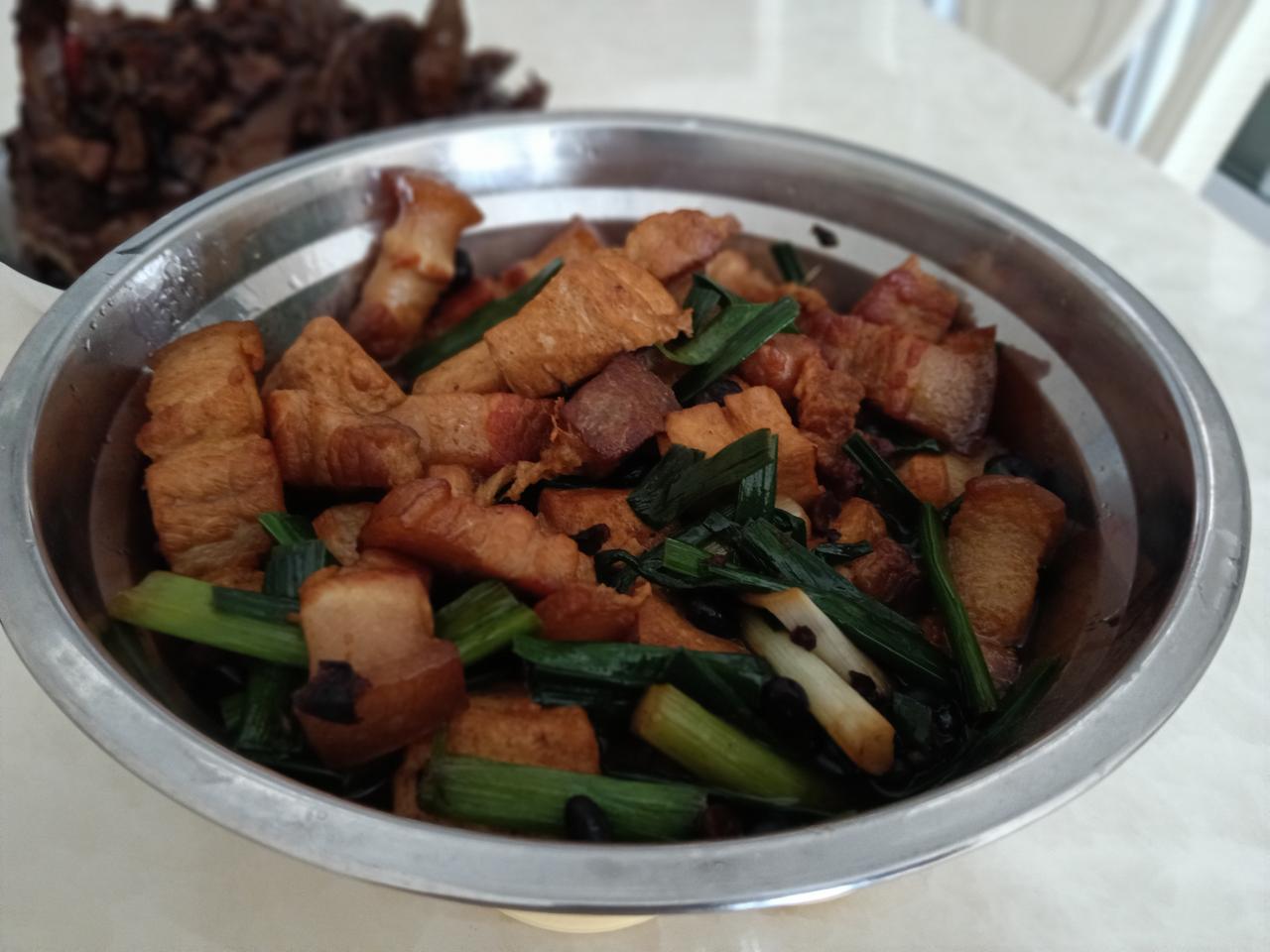 一盘美味的豆腐炖猪肉配蒜叶，美味佳肴。