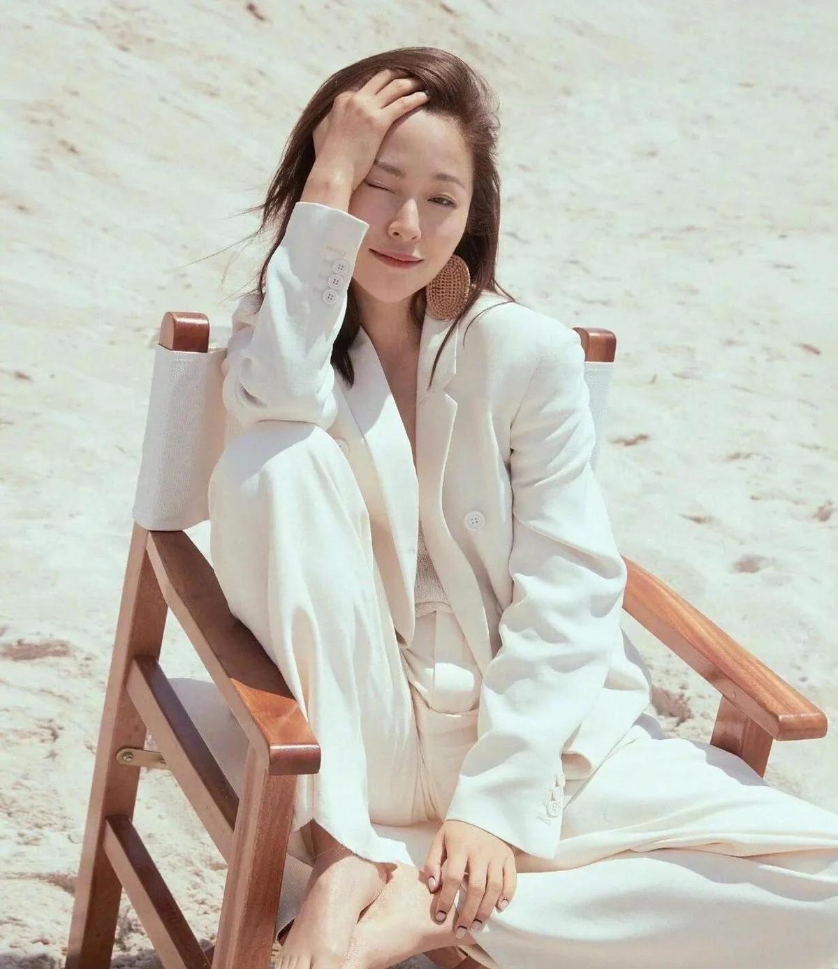 江一燕光脚拍写真，不是作秀，是真想带你走一走她看过的路。
白西装踩沙，黑裙靠树，