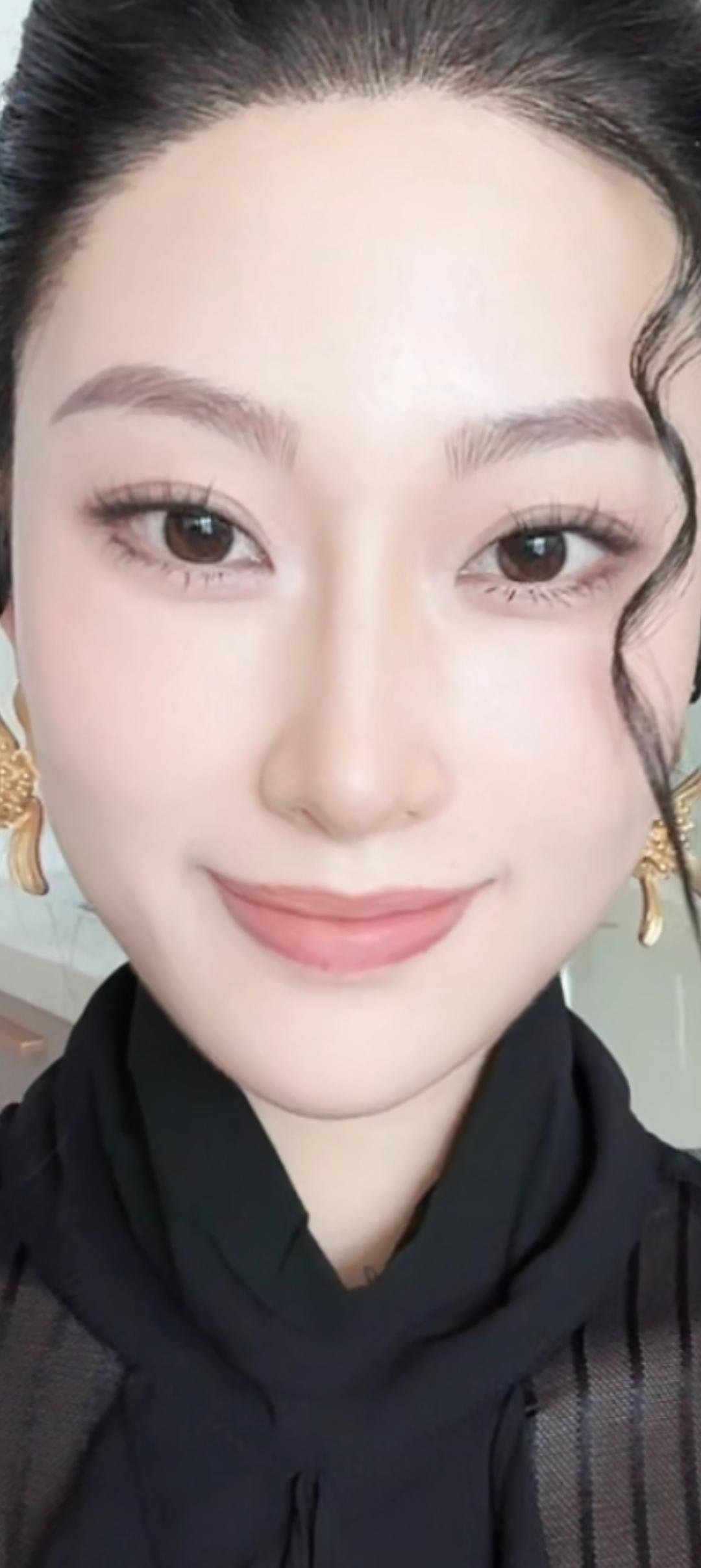 这笑容好甜，耳朵上的金饰真抢眼。
