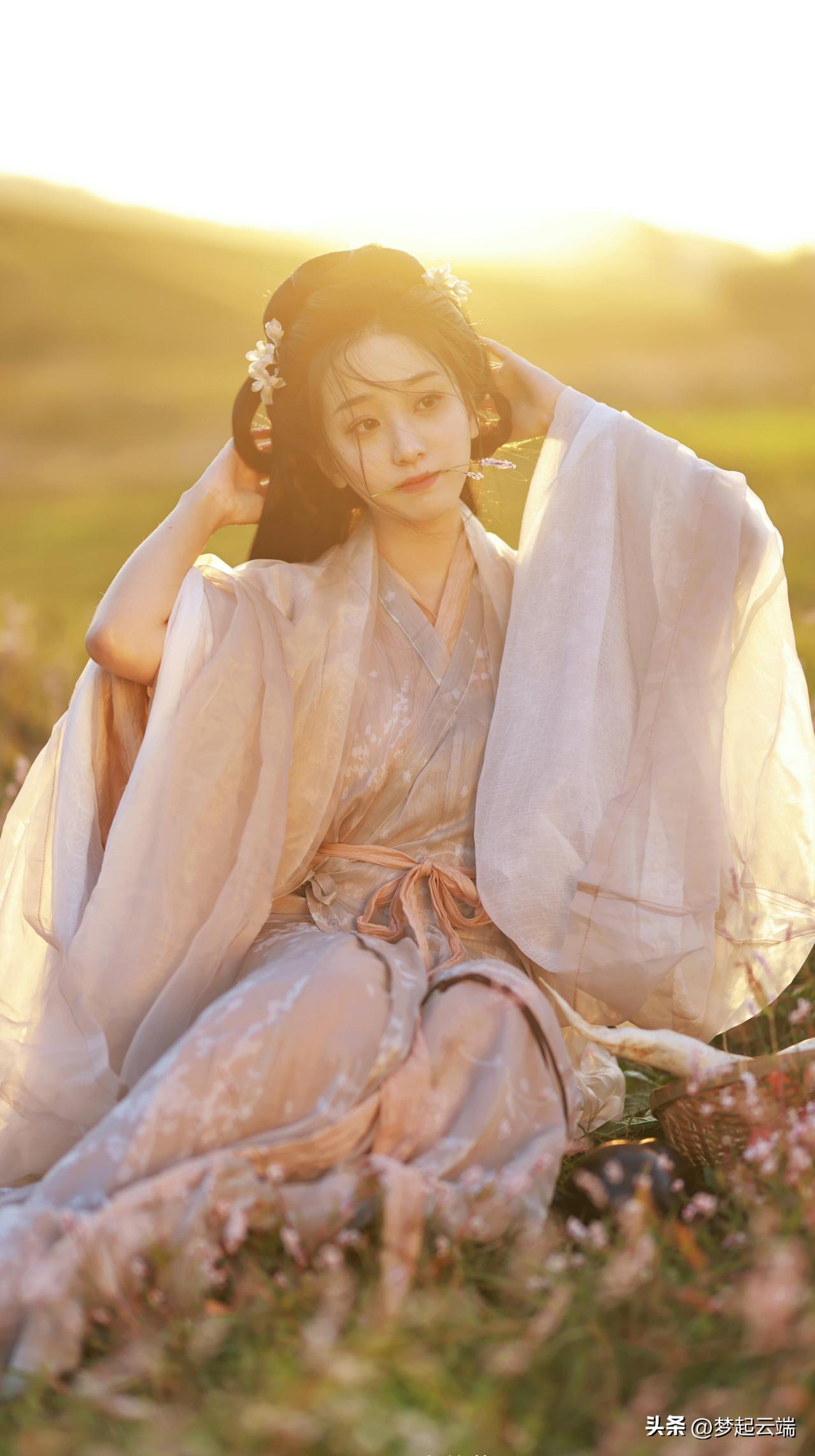 在落日余晖中，古风美人轻抚发髻，唯美如画。