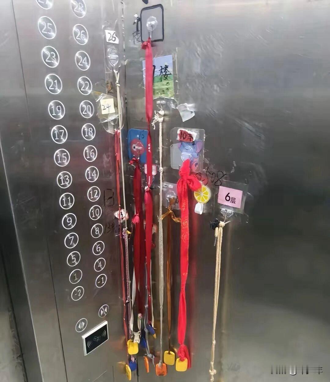 第一眼没看懂这是啥玩意！我以为这电梯成了许愿树呢！仔细一看，挂的都是电梯门禁卡，