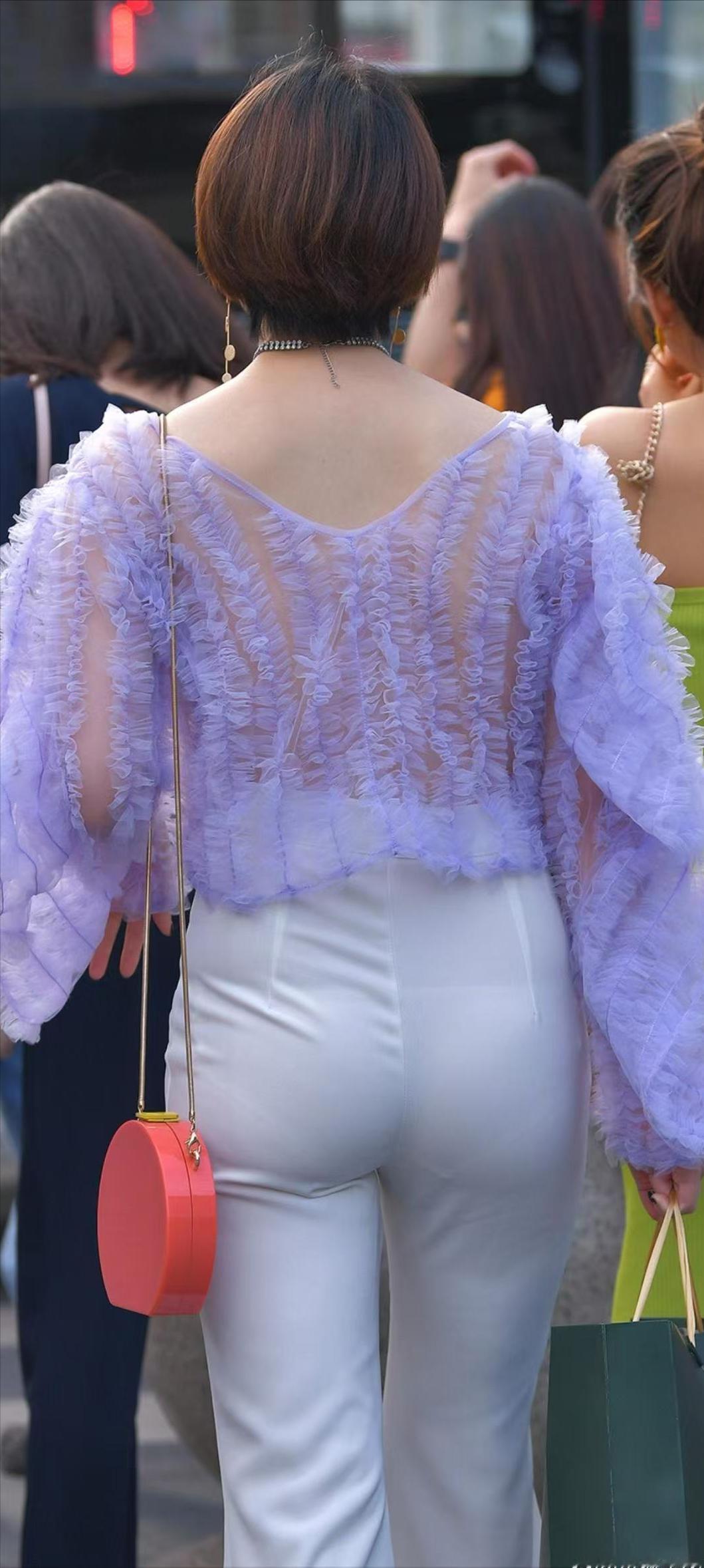 街头偶遇时尚达人，紫色泡泡袖上衣搭配白色裤子，手提小红包，回头率满分