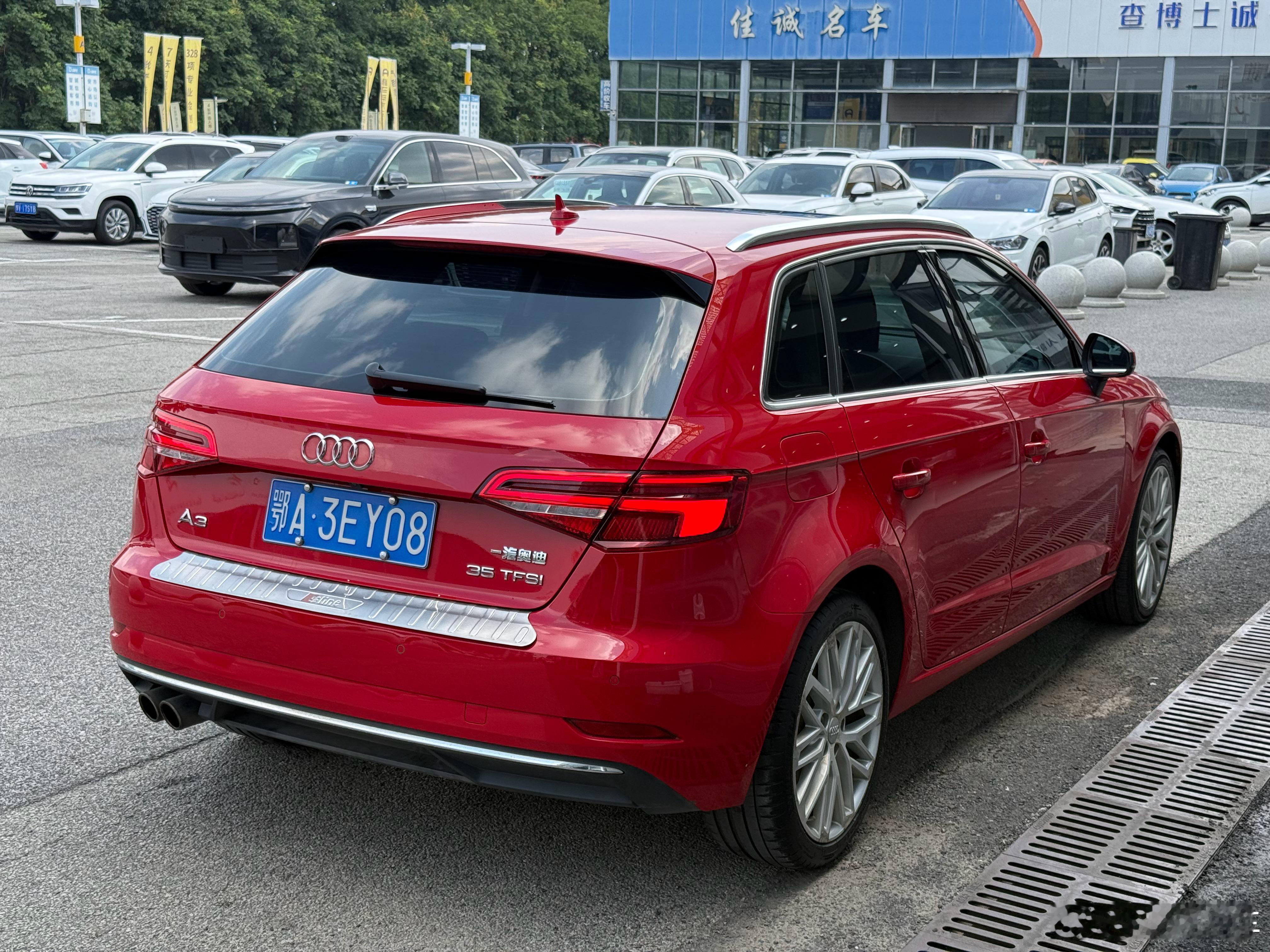 一抹炽烈的红，停在喧嚣的车行院落里这台奥迪A3两厢，一身明艳的红，搭配黑色车顶与