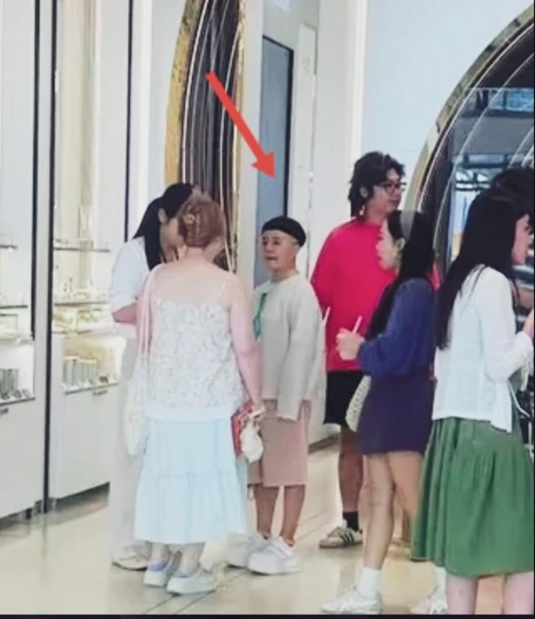金龟子顶着经典锅盖头发型，白上衣配粉色五分裤，脚踩10CM的松糕鞋，站在人群中显