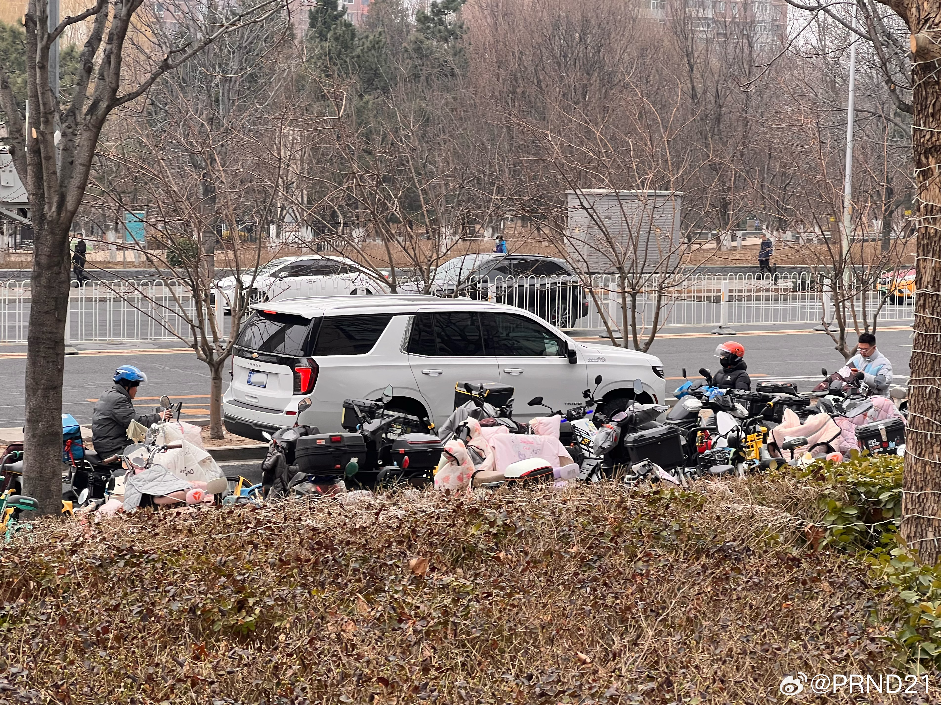 在一大片小电驴旁慢慢驶过的V8雪佛兰太和（Tahoe）。妇科聊汽车常识