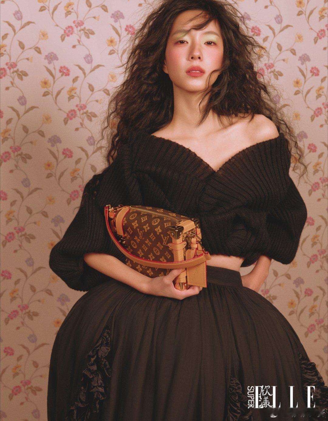 慵懒针织衫裹着春日私语，焦糖色暖阳在发梢跳圆舞曲。碎花墙前藏着少女心事，黑色裙摆