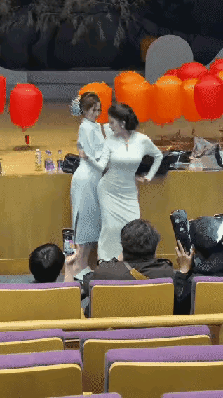 两个女子扭捏作态，搔首弄姿，自以为跳的很美，其实真是丑陋极了。
看着好像是个开会