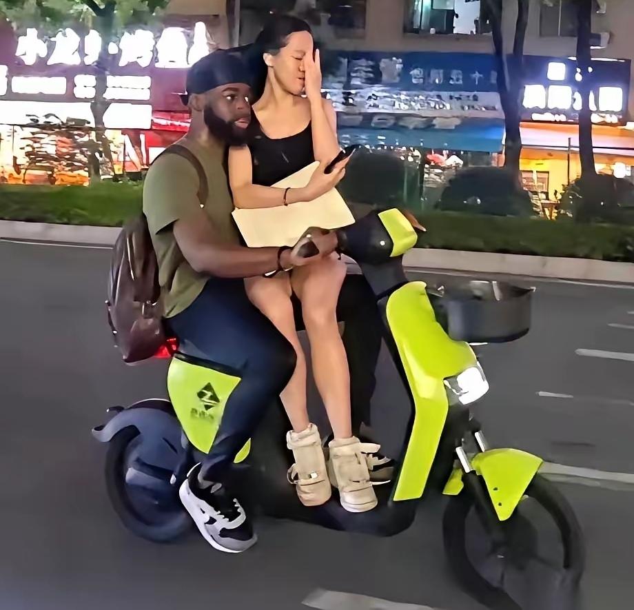 骑电动自行车一定要戴安全头盔，这位黑人小哥骑电动自行车带着自己的女朋友，非但没有